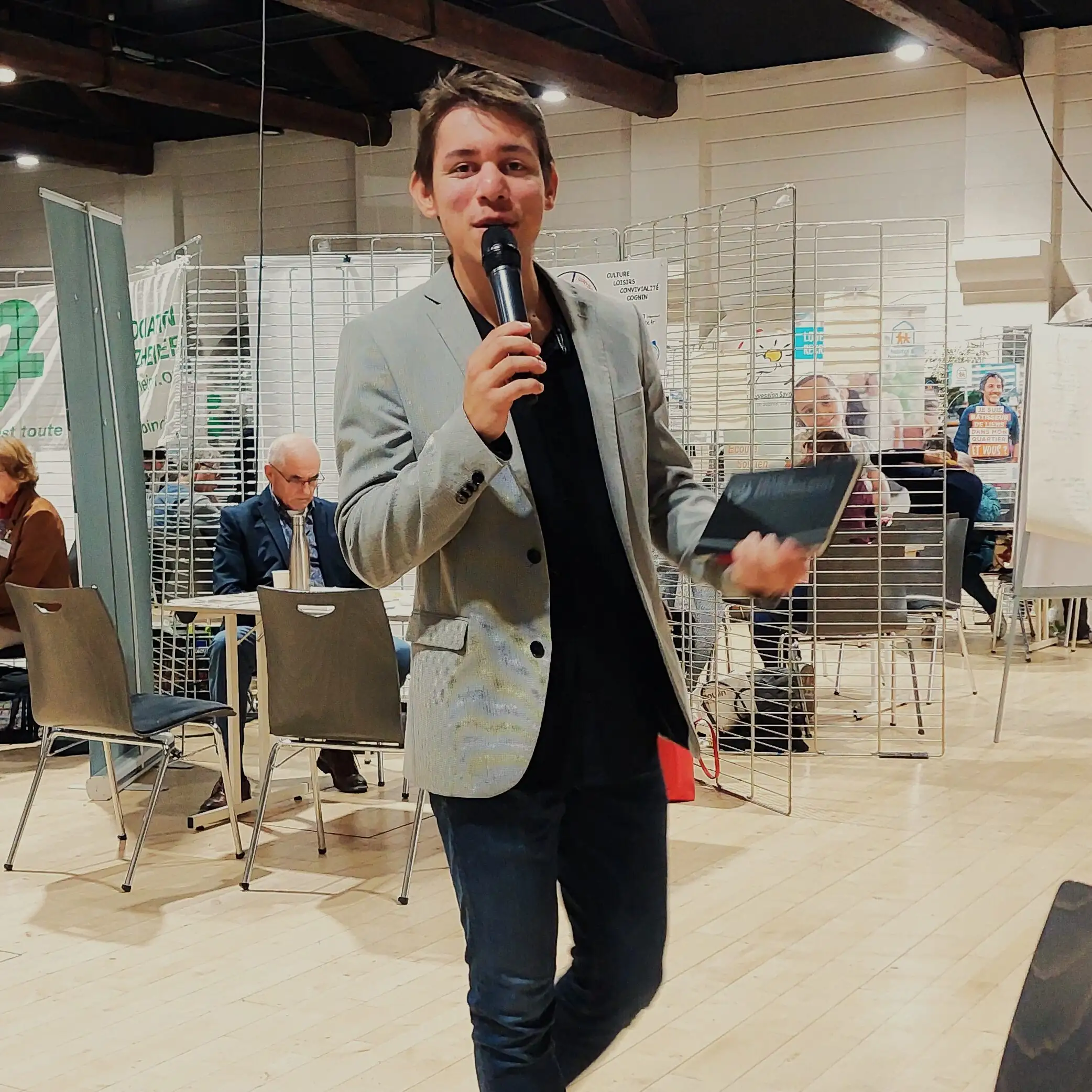 Alexis en costume au micro du salon bien vieillir ensemble à Chambéry