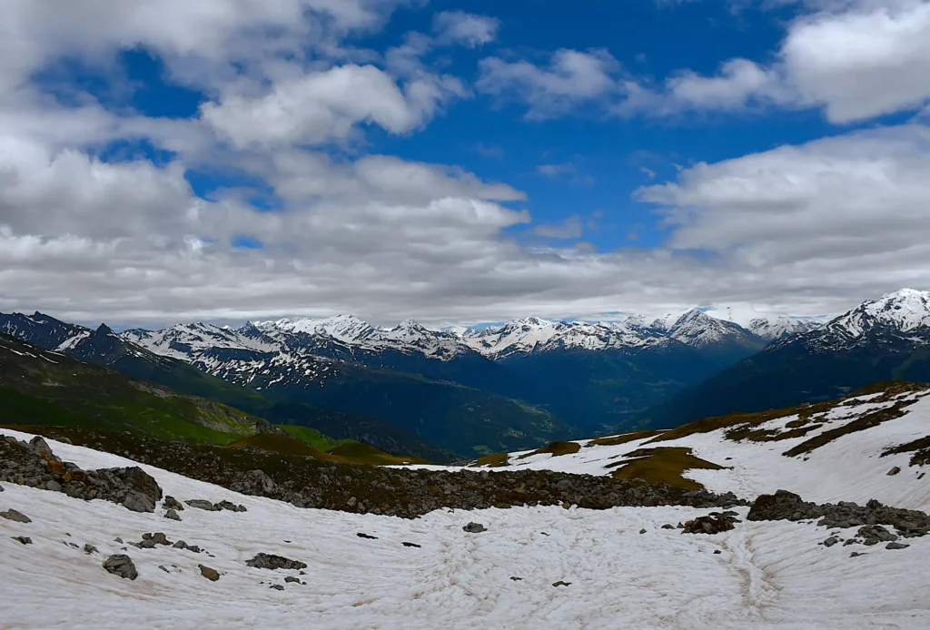 photo de montagne avec de la neige au premier plan et sur le sommet des montagnes au second plan. Une vue sur la vallée