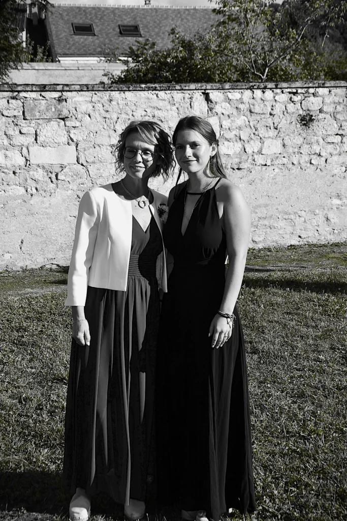 Deux femmes lors d'un mariage avec un mur pour fond