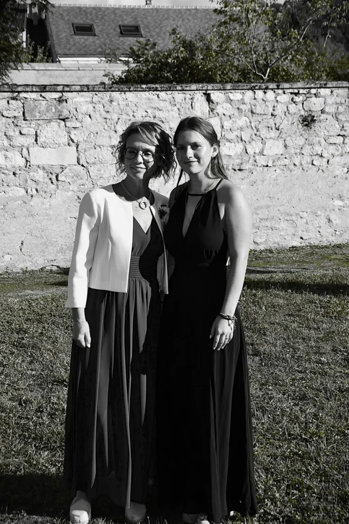 Deux femmes lors d'un mariage avec un mur pour fond