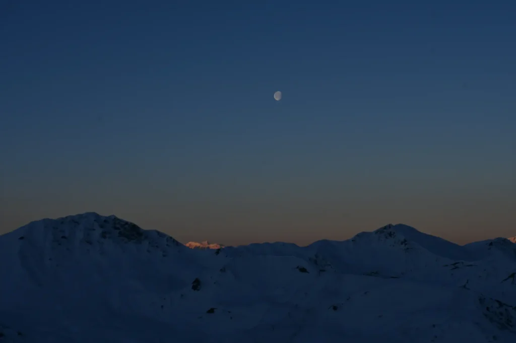 lever de soleil au sommet l'hiver avec la lune au centre