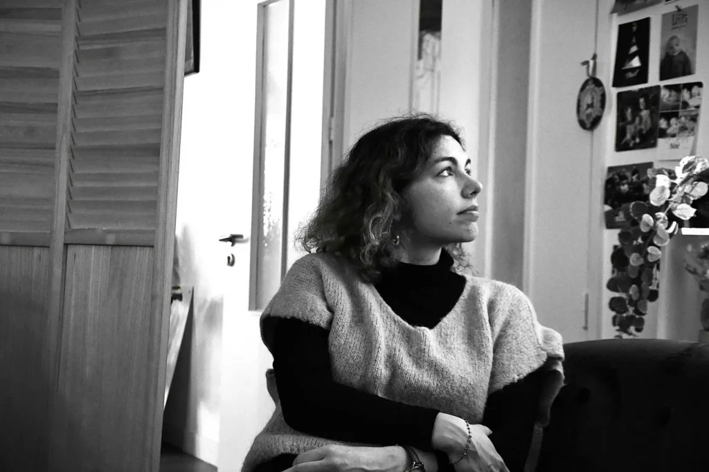 portrait d'une jeune femme regardant à côté assise sur un canapé