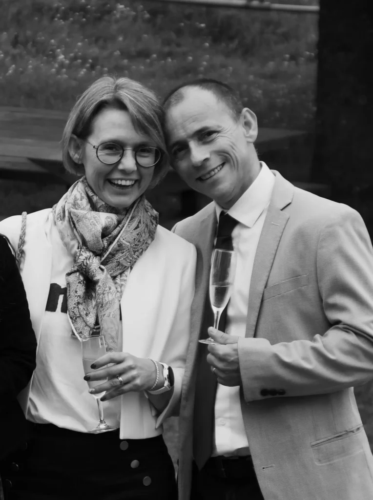 Couple souriant lors d'un mariage avec une flute de champagne à la main