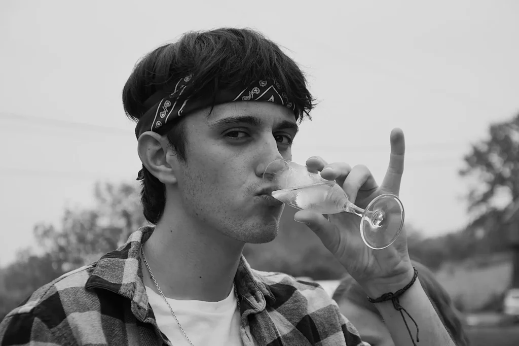 Portrait d'un jeune homme lors d'un mariage en train de boire sa flute de champagne