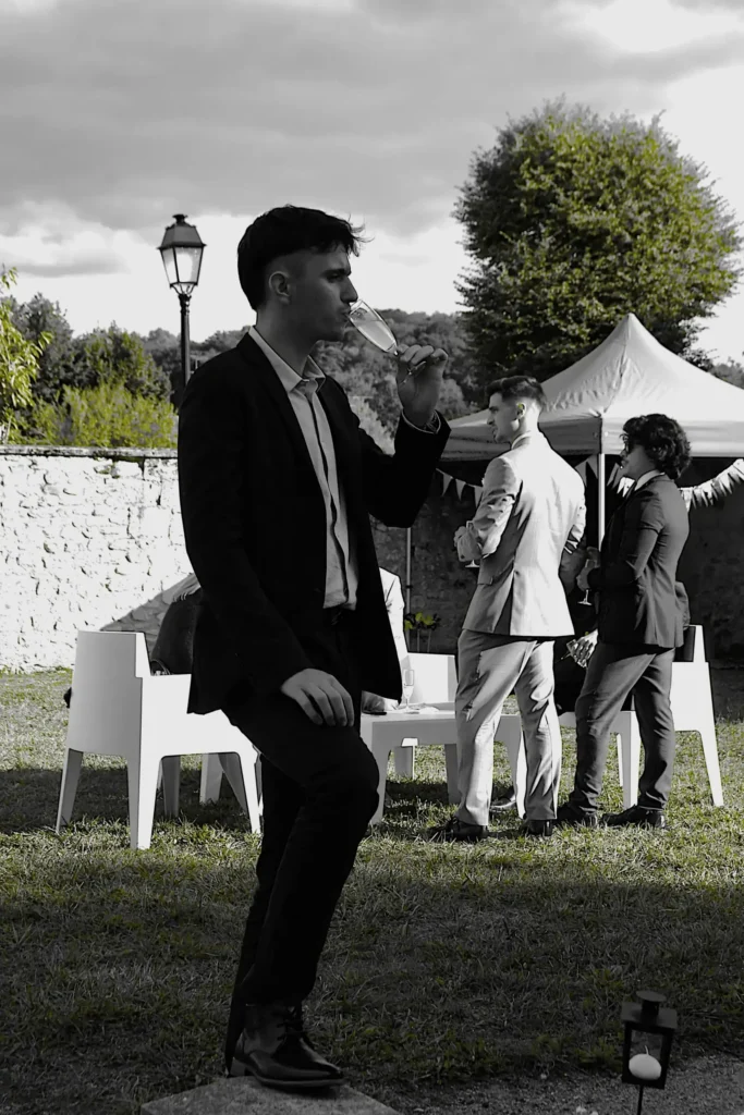 Portrait d'un jeune homme lors d'un mariage en train de boire sa flute de champagne
