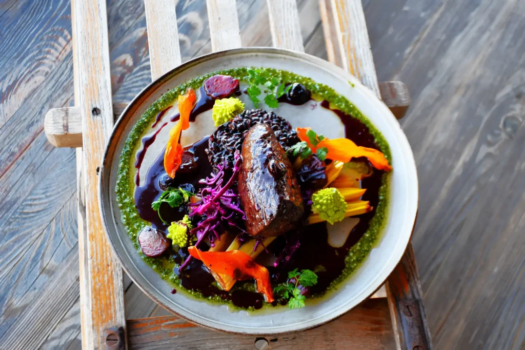 plat de restaurant, du cerf agrémenté de sa réduction et accompagné de légumes