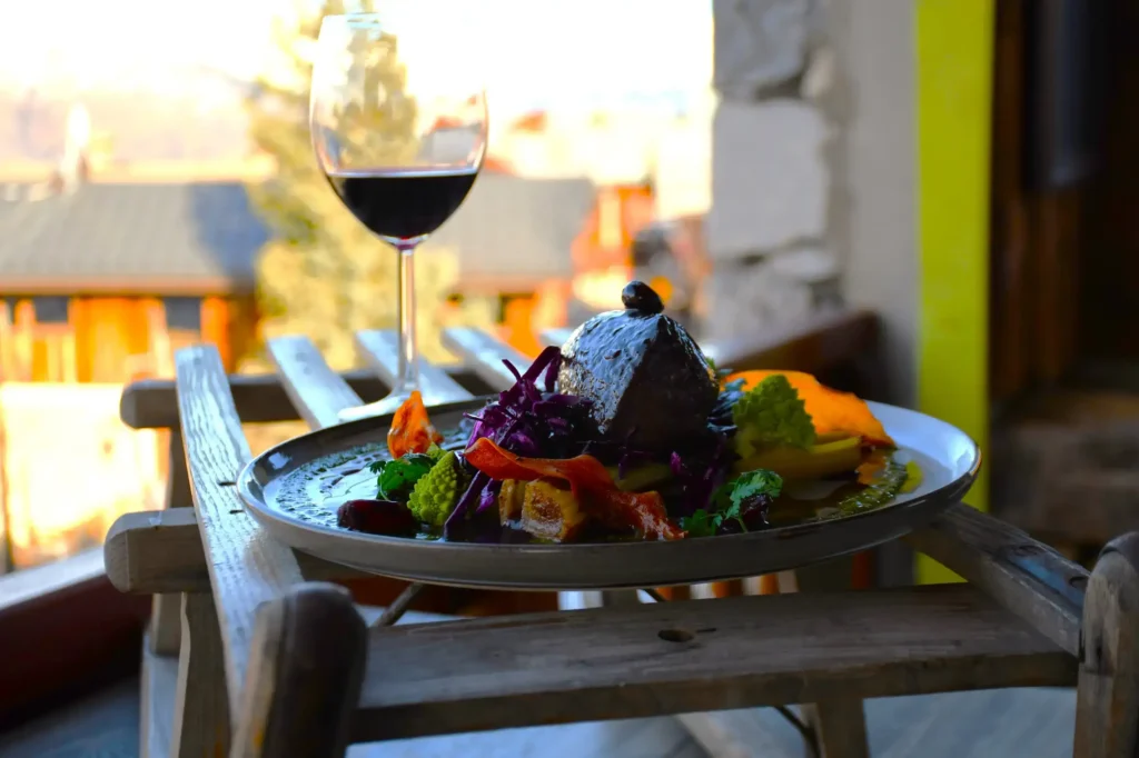 plat de restaurant, du cerf agrémenté de sa réduction et accompagné de légumes et de son verre de vin rouge