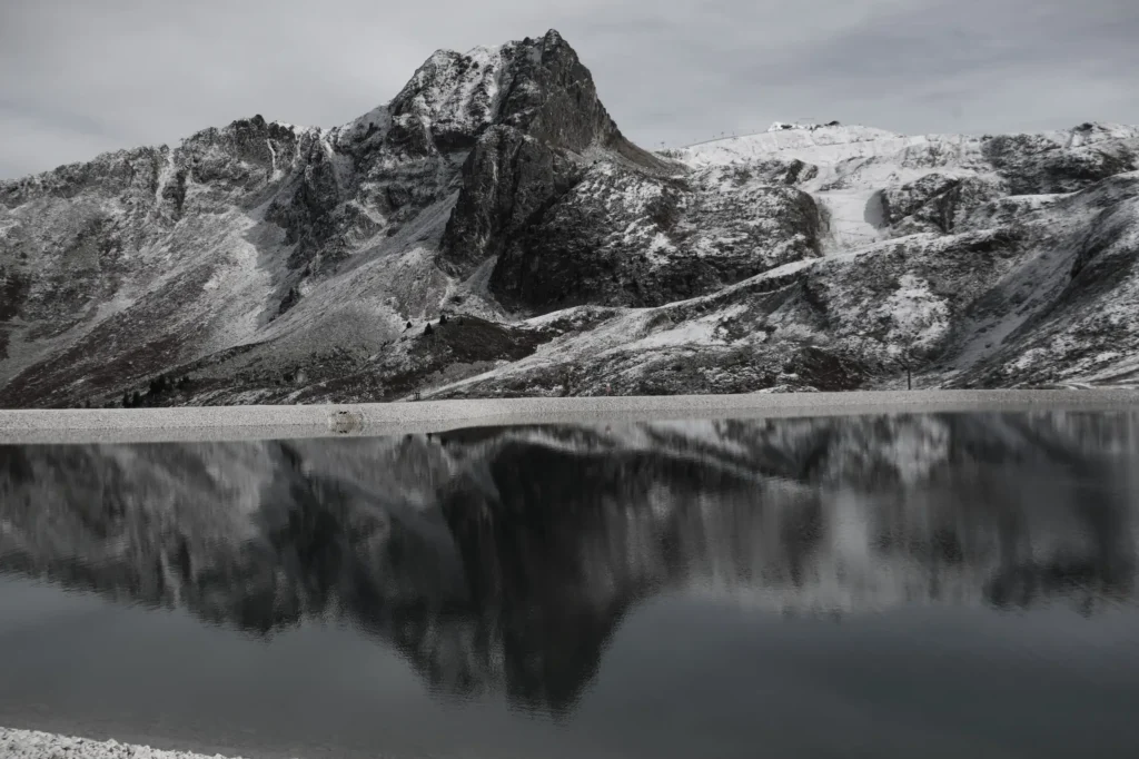 lac en premier plan et montagne au second plan qui se reflète dans l'eau. Les sommets sont saupoudrés de neige