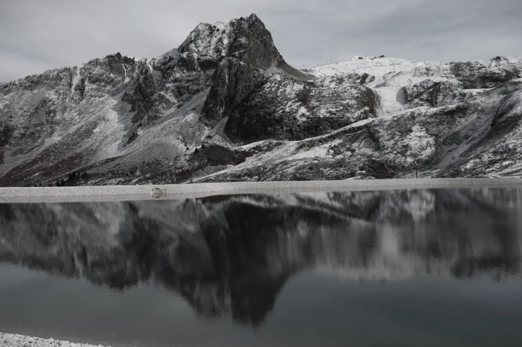 lac en premier plan et montagne au second plan qui se reflète dans l'eau. Les sommets sont saupoudrés de neige