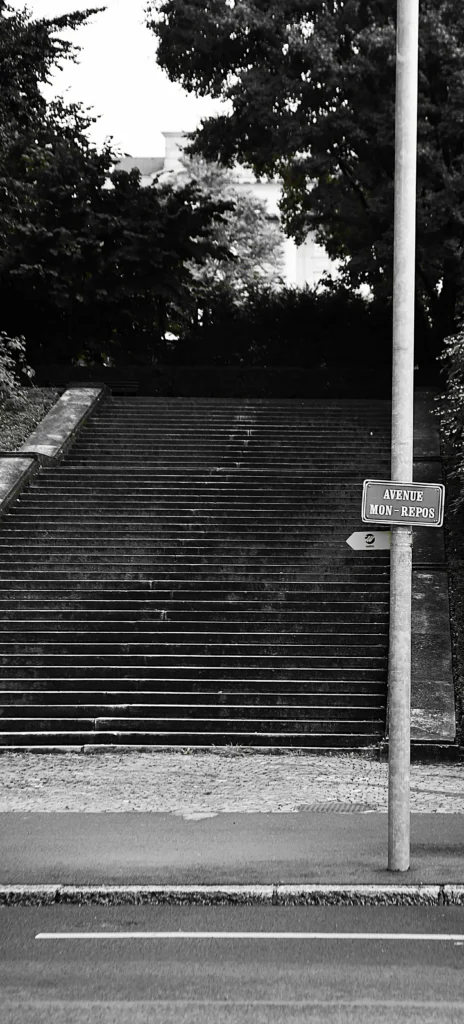 Escalier à l'entrée d'un parc avec un panneau au pied "avenue mon-repos"