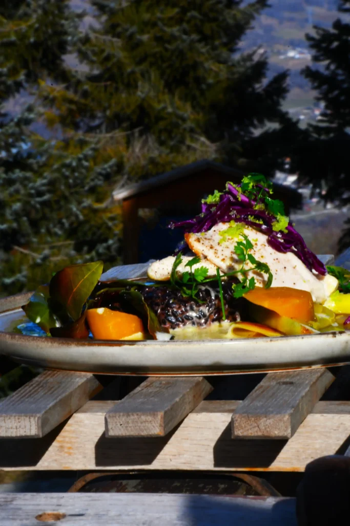 plat de restaurant : omble chevalier accompagné de son riz noir et de ses légumes